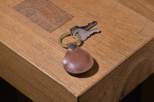 AirTag holder with brass keychain ring, brown veg tan leather, hand made (front shot with keys attached, full)