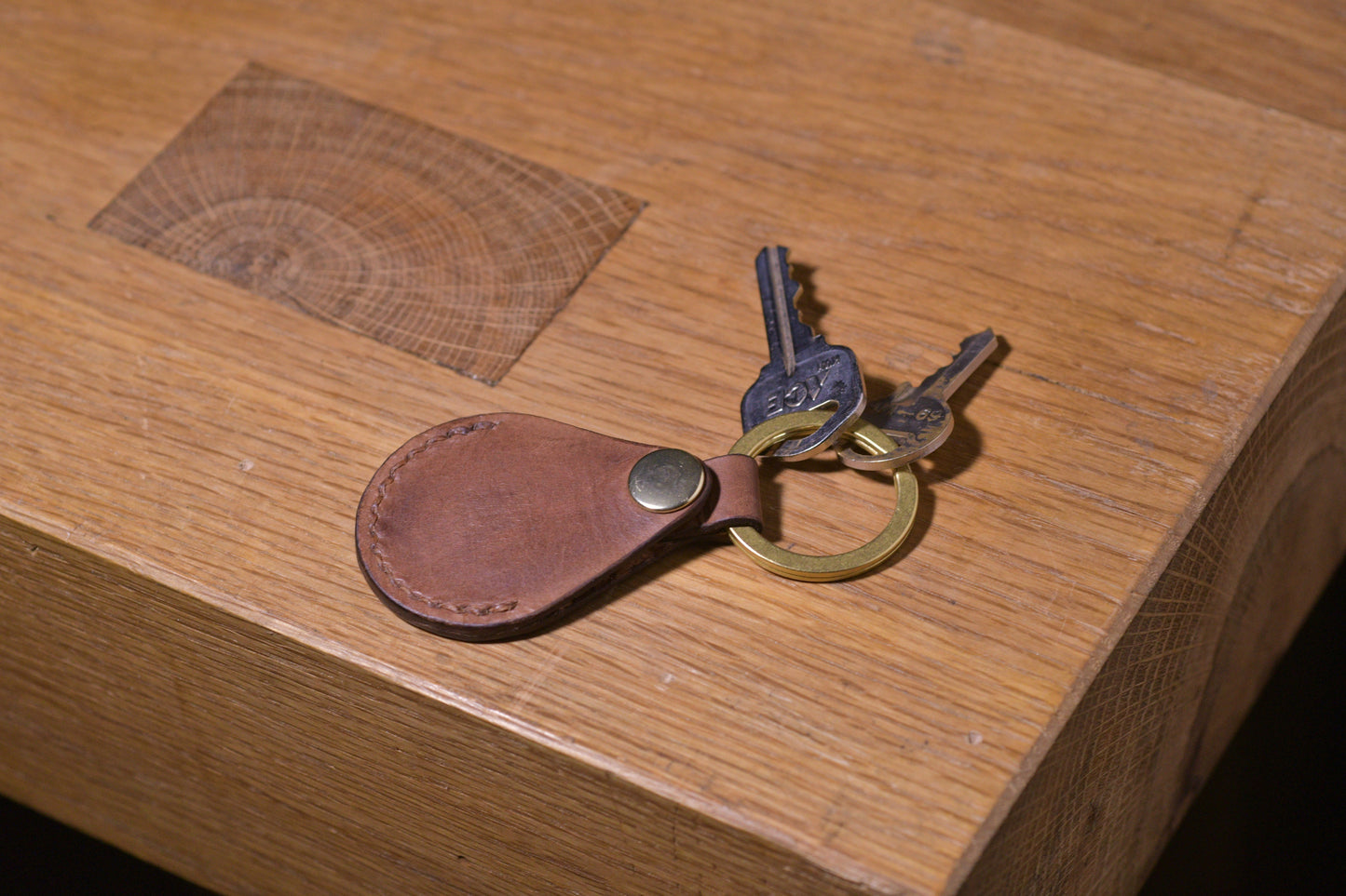 AirTag holder with brass keychain ring, brown veg tan leather, hand made (front shot with keys attached, empty, alt.)