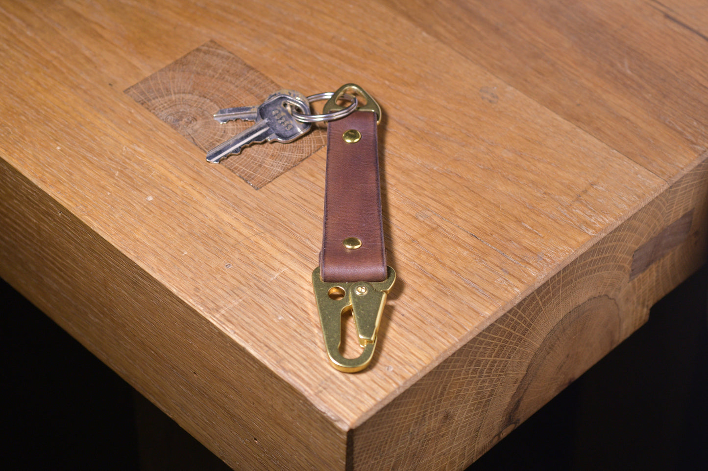 Keychain with carabiner style clip and brass hardware, brown veg tan leather, hand made (angle shot with keys)