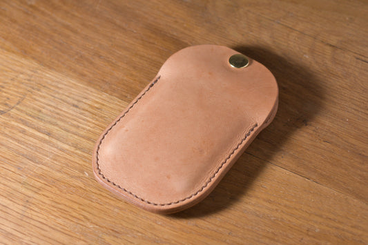 Minimal single pocket card wallet with brass snap closure and pop open mechanism, natural veg tan leather, hand made (angle)