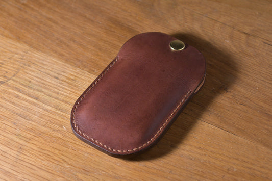 Minimal single pocket card wallet with brass snap closure and pop open mechanism, brown veg tan leather, hand made (angle)