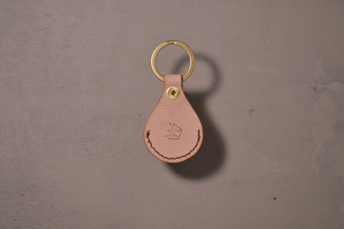 AirTag holder with brass keychain ring, natural veg tan leather, hand made (back side with logo)