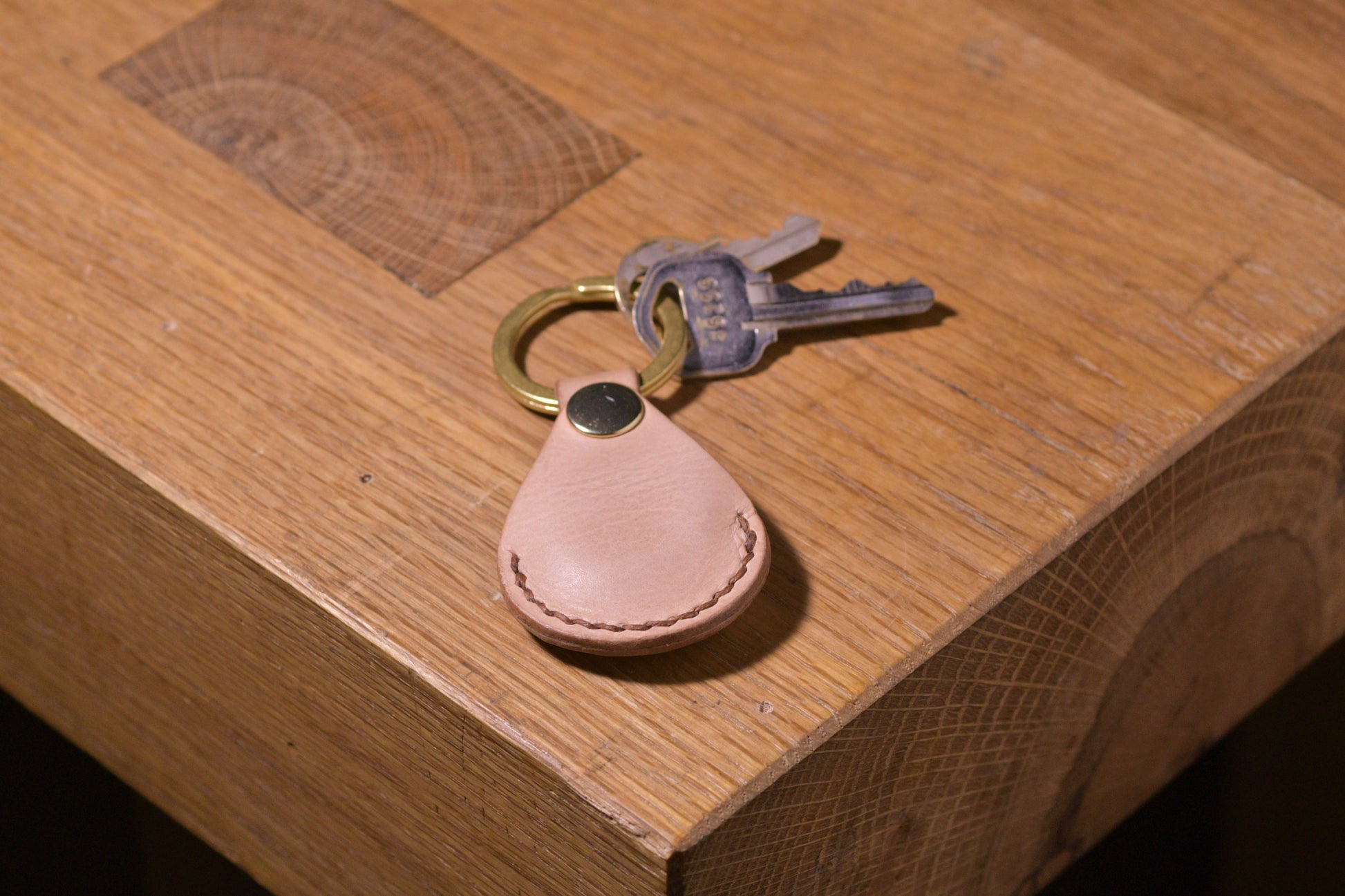 AirTag holder with brass keychain ring, natural veg tan leather, hand made (front shot with keys attached, full)