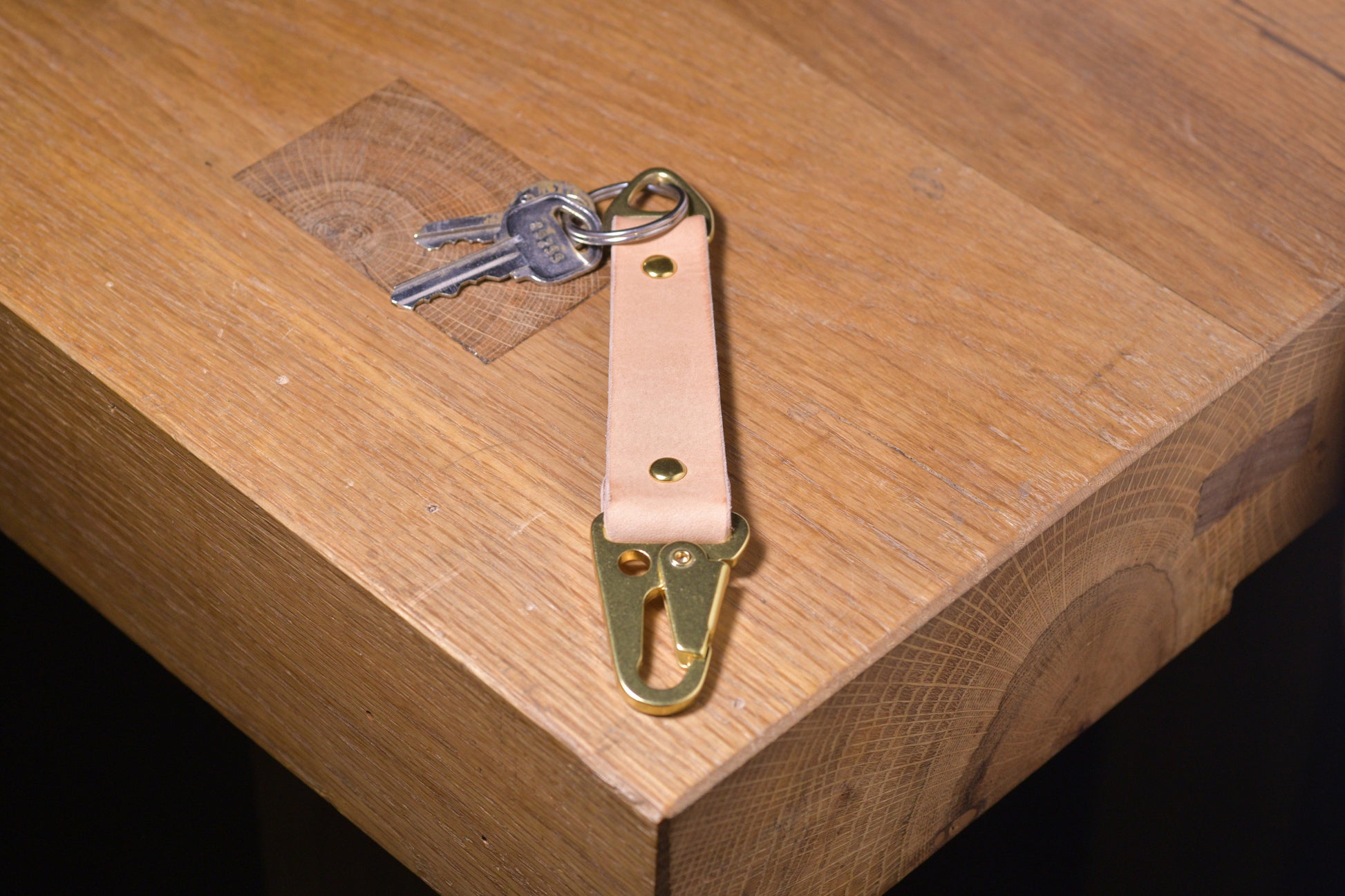 Keychain with carabiner style clip and brass hardware, natural veg tan leather, hand made (angle shot with keys)