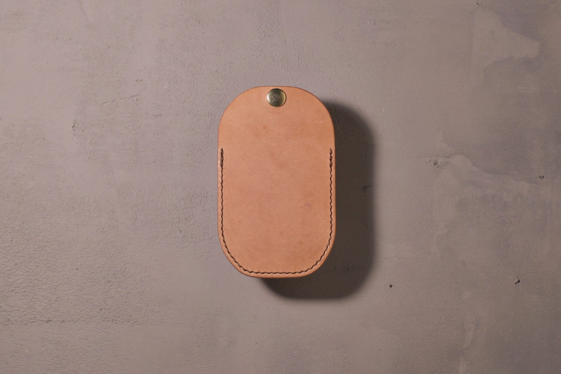 Minimal single pocket card wallet with brass snap closure and pop open mechanism, natural veg tan leather, hand made