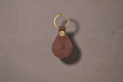 AirTag holder with brass keychain ring, brown veg tan leather, hand made (back side with logo)