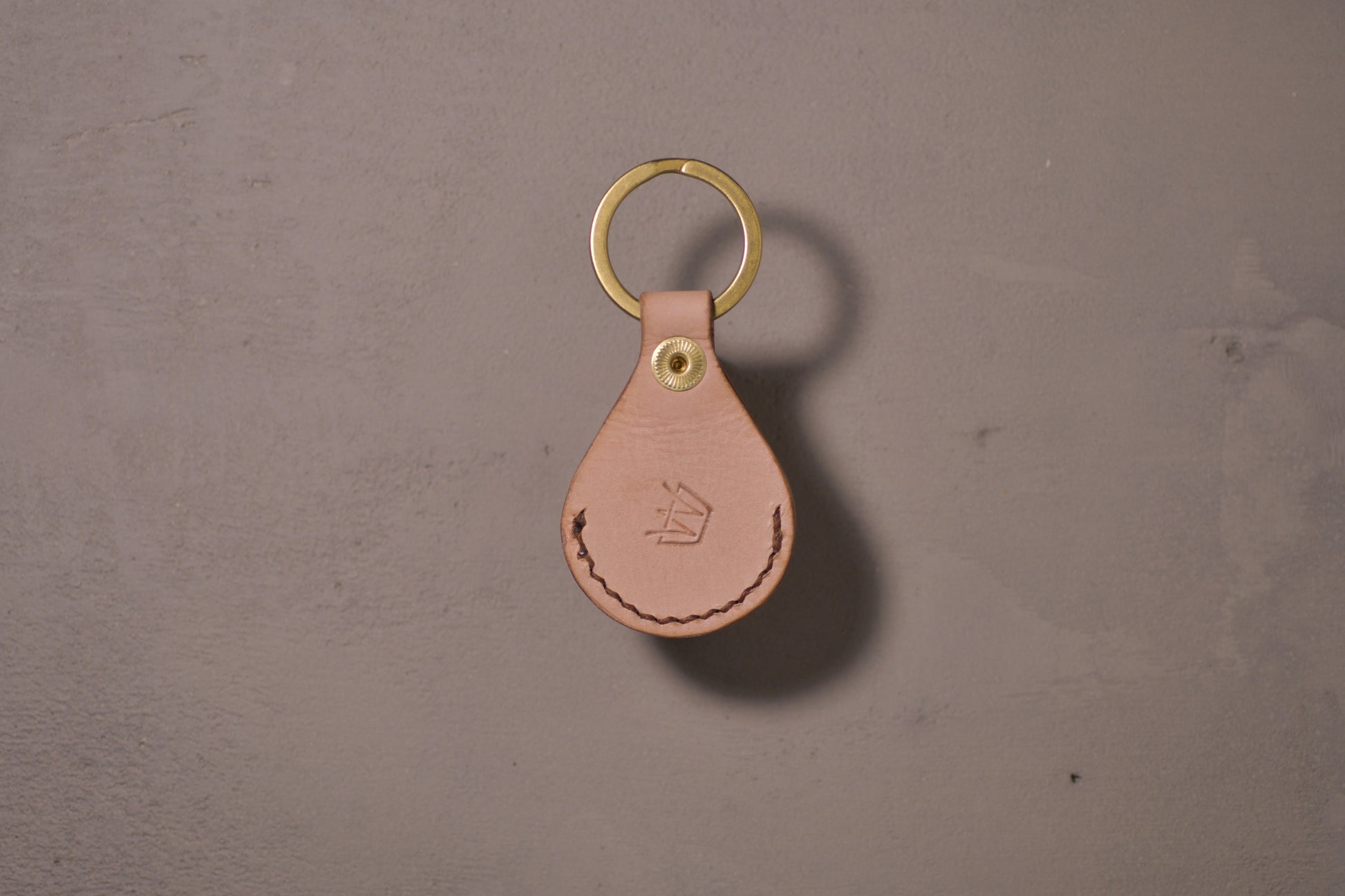 AirTag holder with brass keychain ring, natural veg tan leather, hand made (back side with logo)